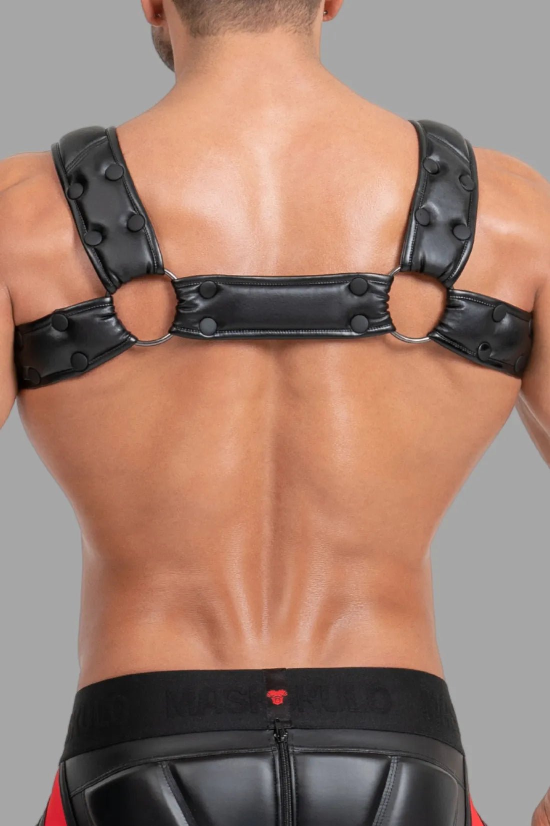 Black and red Maskulo Body Harness with Push-up Effect for adults. Polyester/polyurethane blend harness with adjustable straps and PU leather piping.
