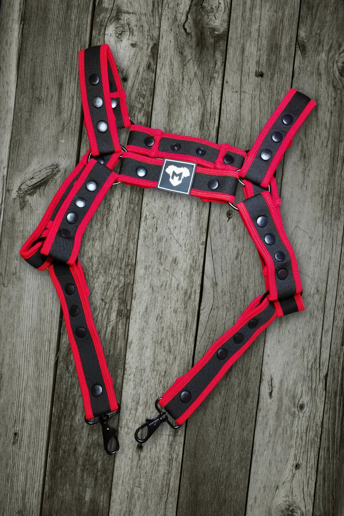 Maskulo Riven Hexguard Neoprene Body Harness in black and red. Adjustable one-size-fits-most design with a cock ring and metal ring.