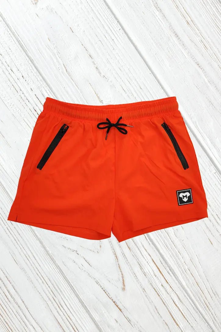 Maskulo Jedd Synther Soft Shorts in orange. Nylon-polyester shorts with 2 side zip-pockets, soft white mesh lining, and 3D PVC label.
