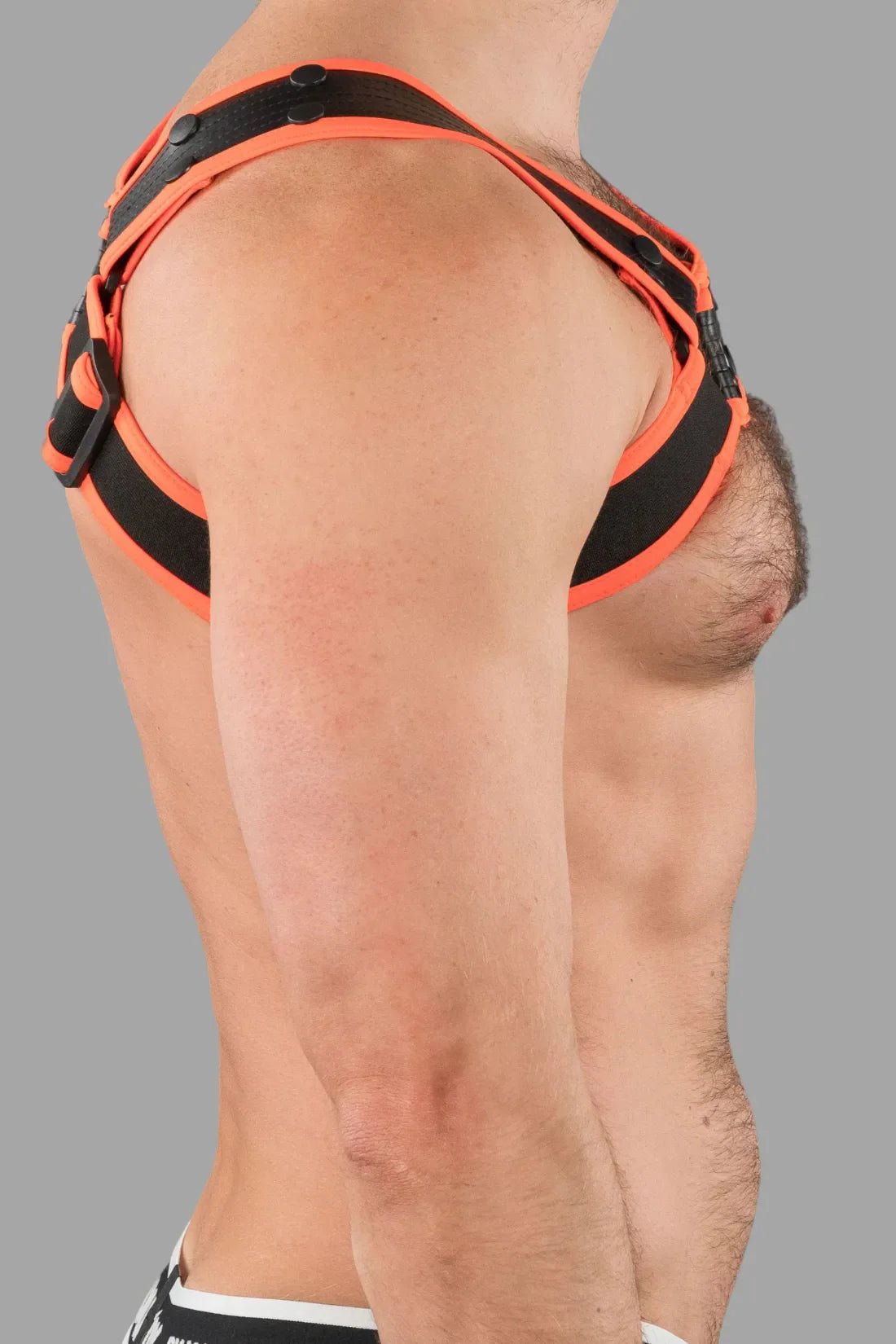 Outtox by Maskulo Bulldog Harness in black and orange. Stretchable polyester/PU leather straps with adjustable snaps for a bold, fetish look.